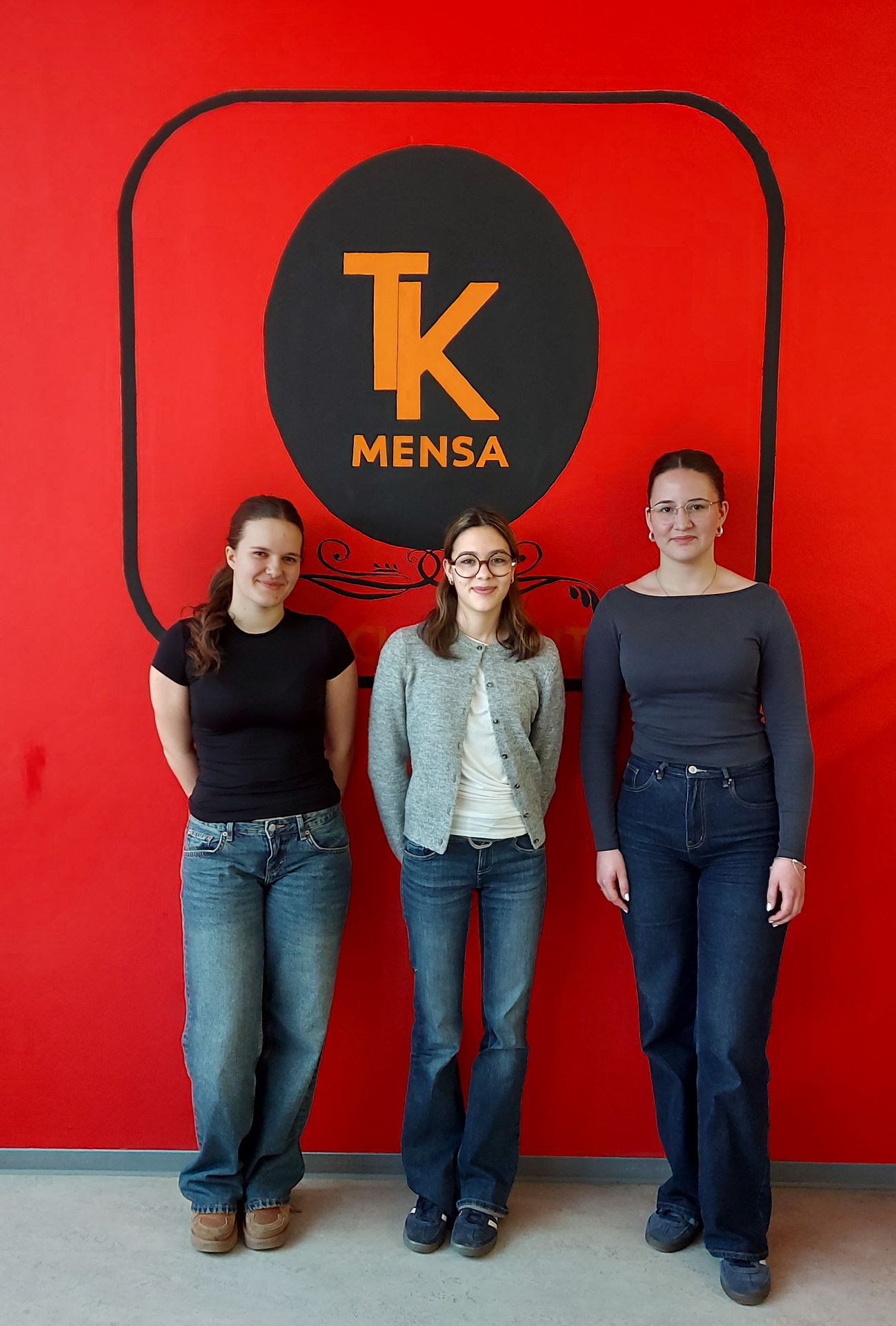 Die drei Künstlerinnen vor dem Mensa-Logo